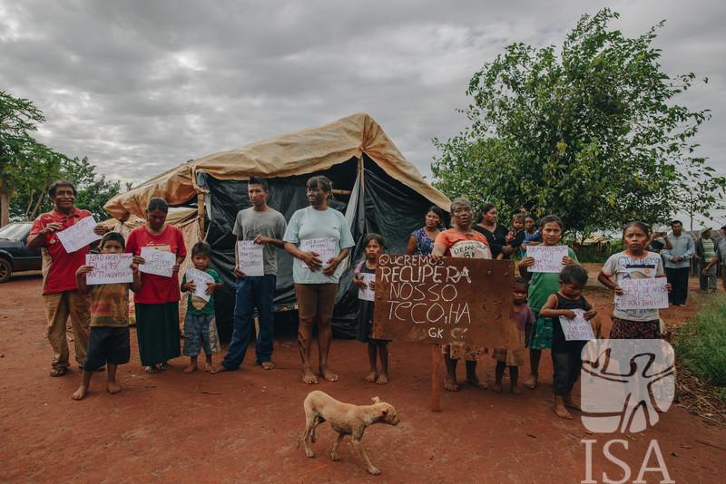 Pessoas carregam cartazes com mensagens políticas sobre a luta e o direito dos povos indígenas ao território, durante visita da Comissão Interamericana de Direitos Humanos (CIDH) na Terra Indígena Guyraroká, do povo Guarani e Kaiowá, localizada no município de Caarapó (MS), realizada em novembro de 2018